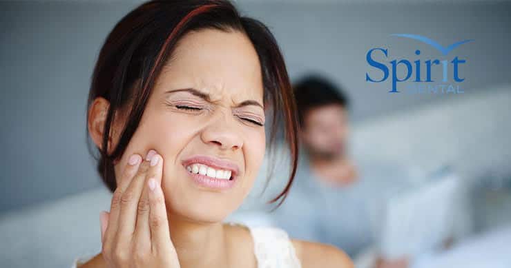 Lady with a cavity holding her mouth in pain