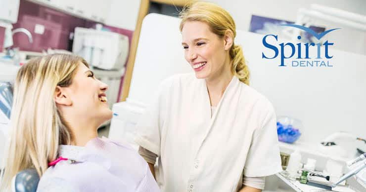 Lady in dentist chair talking about insurance options