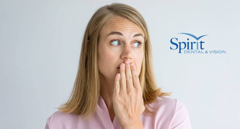 Photo of lady covering her mouth with her hand and looking to the side.