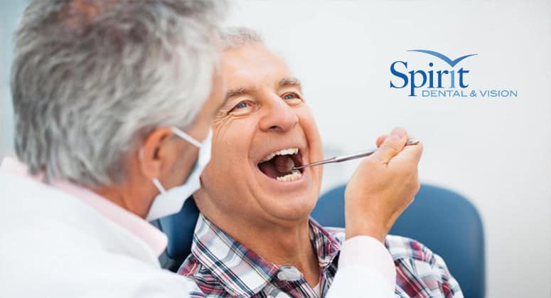 Man with receding gums in dentist chair getting checked.