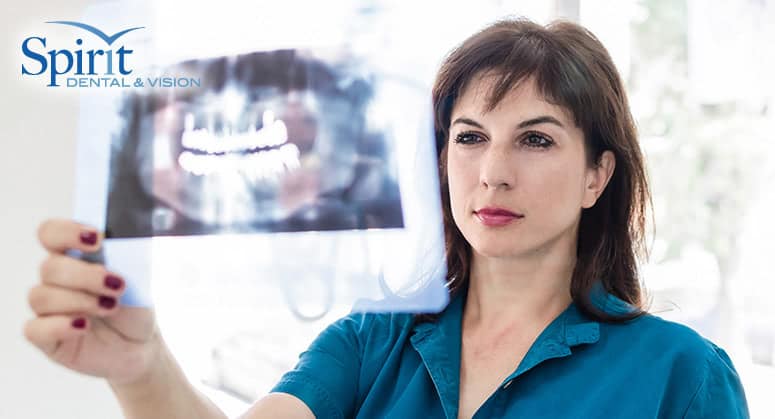 Lady dentist looking at x-ray of teeth