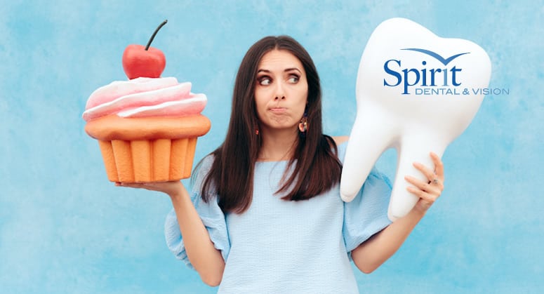 Lady holding a large cupcake and tooth.