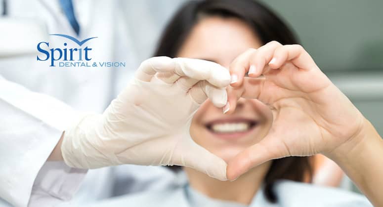 Dentist and patient making a heart with their hands.