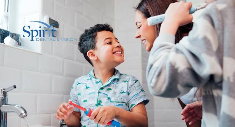 Boy showing his mom how well he brushed.