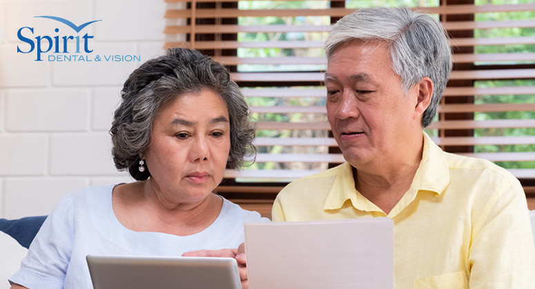 Older couple looking over paperwork of what is covered with their dental insurance