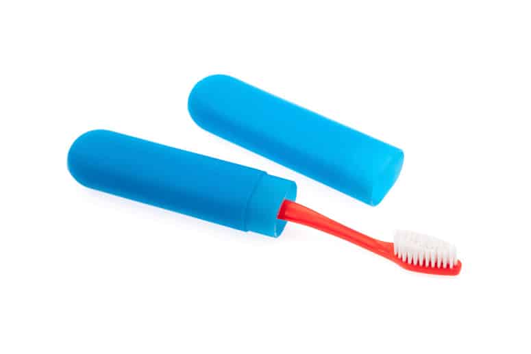 A plastic toothbrush container with a toothbrush in it