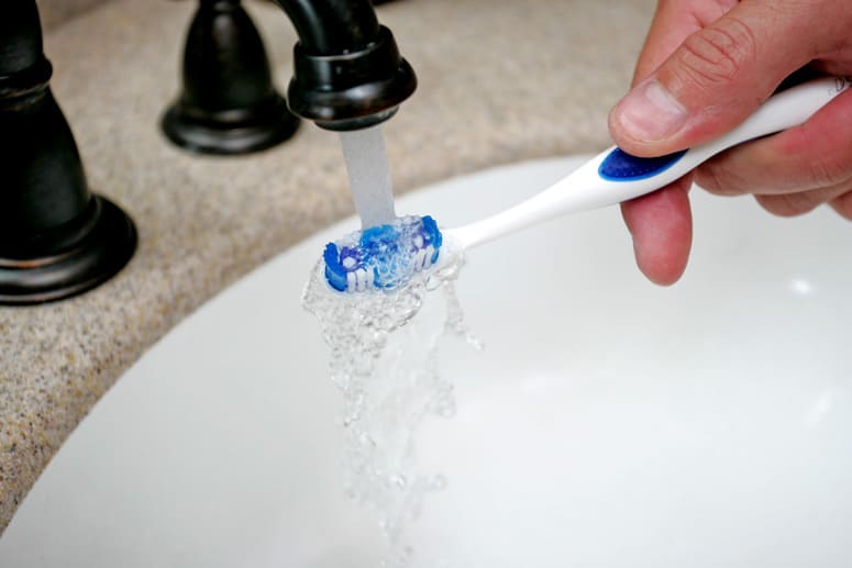 Washing a toothbrush in the sink