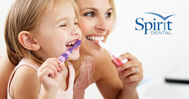 Mother and daughter brushing teeth together