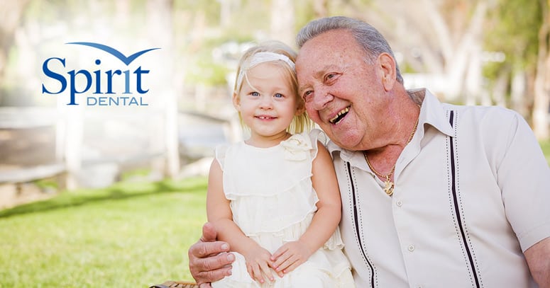 Senior man with granddaughter, laughing with teeth showing