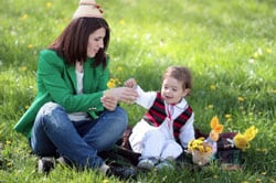 Mother and daughter playing with flowers in the grass